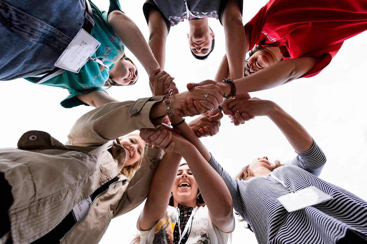 A group of Students linking arms together as apart of a group bonding activity. 
